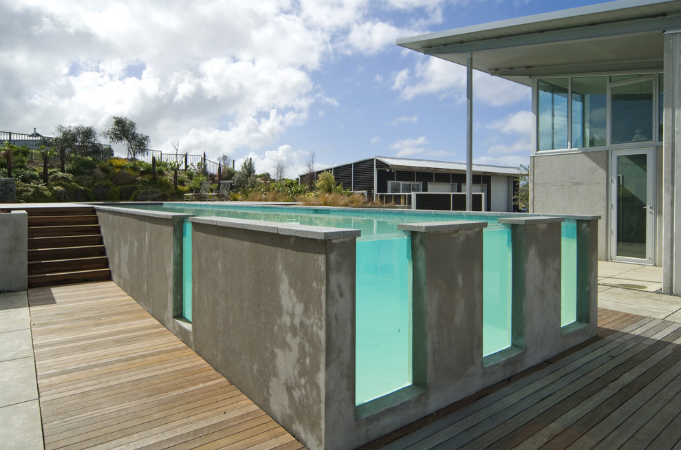 На фото: прямоугольный, наземный бассейн в современном стиле с настилом