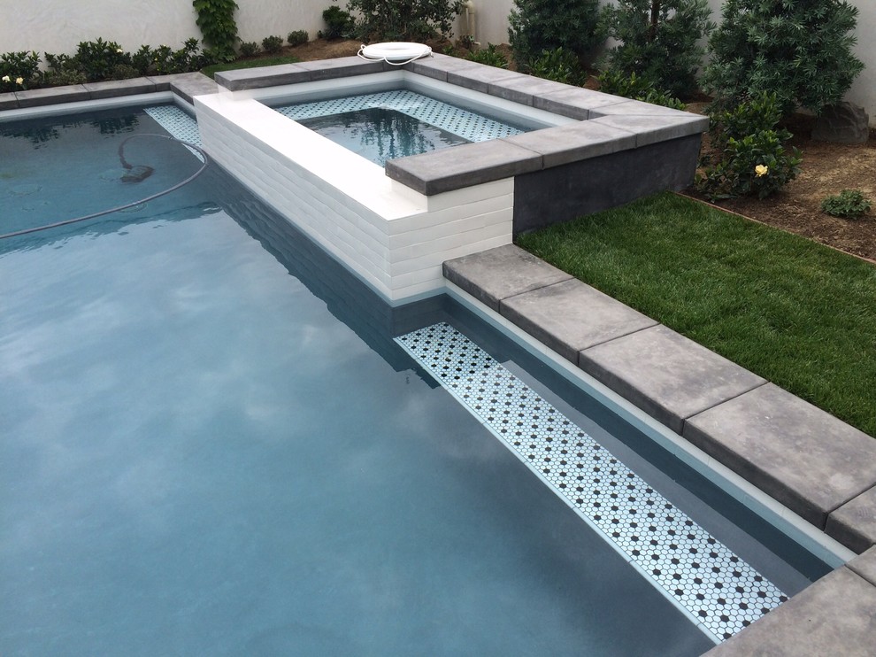 Modern inredning av en liten rektangulär pool, med betongplatta