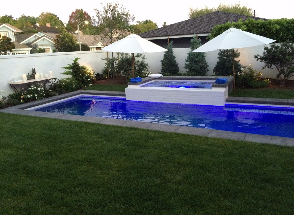 Imagen de piscina alargada actual pequeña rectangular en patio delantero con losas de hormigón