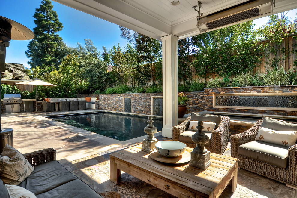 Foto di una piscina monocorsia stile americano rettangolare di medie dimensioni e dietro casa con fontane e lastre di cemento