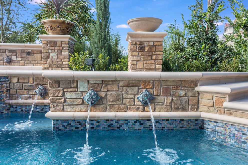 Идея дизайна: большой бассейн произвольной формы на заднем дворе в стиле неоклассика (современная классика) с покрытием из каменной брусчатки