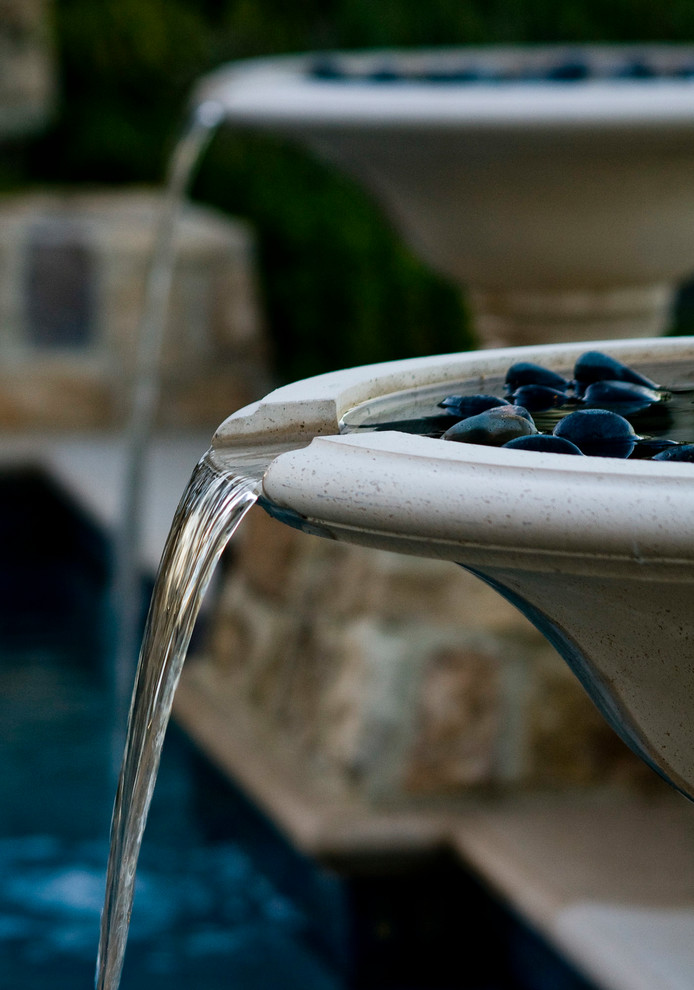 Foto de piscina con fuente natural mediterránea a medida en patio trasero con adoquines de piedra natural