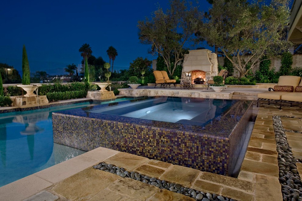 Inspiration for a large contemporary back rectangular lengths hot tub in Orange County with natural stone paving.