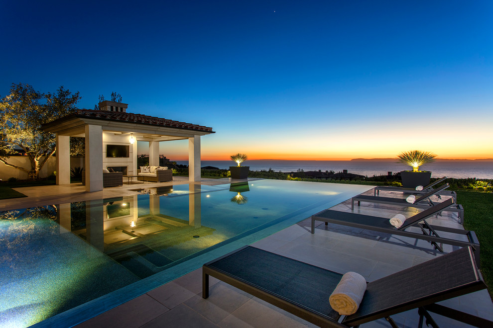 This is an example of a mediterranean back rectangular infinity swimming pool in Orange County.
