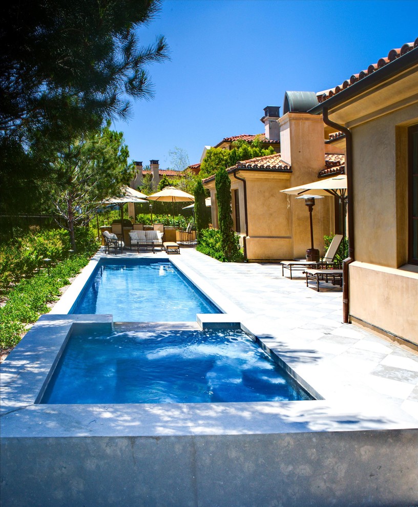 Стильный дизайн: большой спортивный, прямоугольный бассейн на заднем дворе в средиземноморском стиле с джакузи и покрытием из бетонных плит - последний тренд