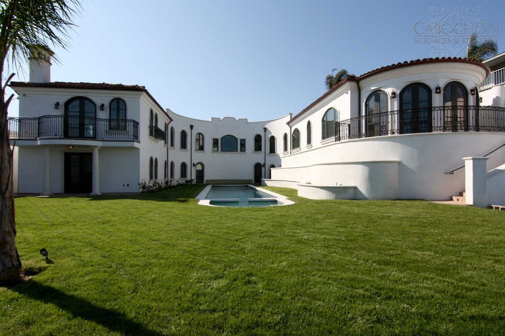 Imagen de piscinas y jacuzzis alargados mediterráneos grandes rectangulares en patio trasero con adoquines de hormigón
