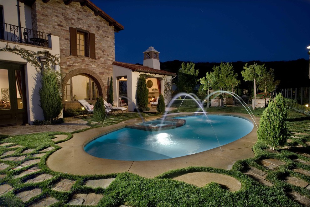 Источник вдохновения для домашнего уюта: большой круглый бассейн на заднем дворе в средиземноморском стиле с фонтаном и покрытием из каменной брусчатки