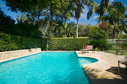 Cette photo montre une piscine arrière tendance de taille moyenne et rectangle avec des pavés en pierre naturelle.