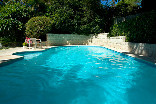 This is an example of a medium sized contemporary back rectangular swimming pool in Sydney with natural stone paving.