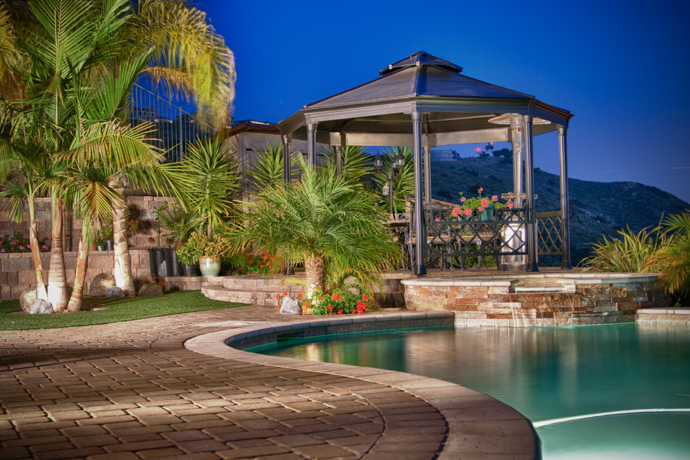 Foto di una grande piscina naturale classica personalizzata dietro casa con fontane e pavimentazioni in cemento