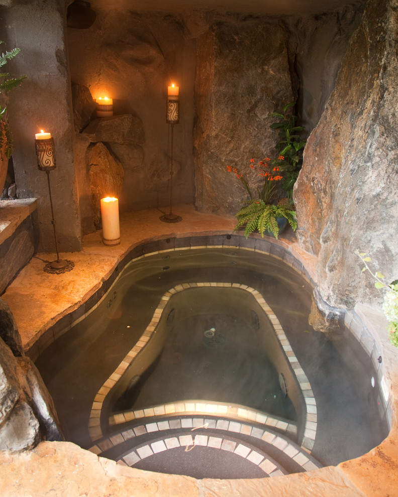 Example of a mid-sized mountain style backyard stone and custom-shaped natural hot tub design in Denver