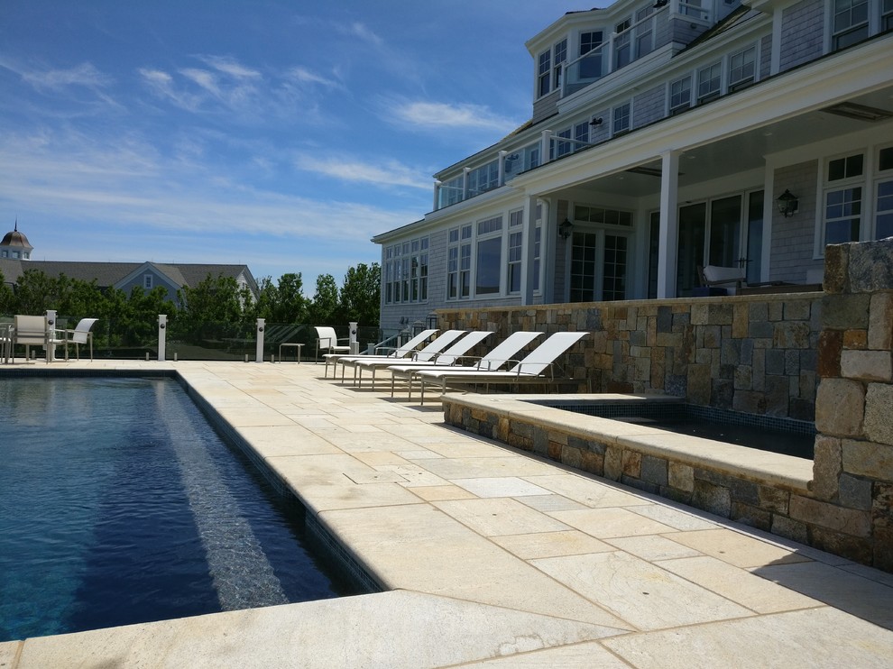 Modelo de casa de la piscina y piscina marinera rectangular en patio trasero con adoquines de piedra natural