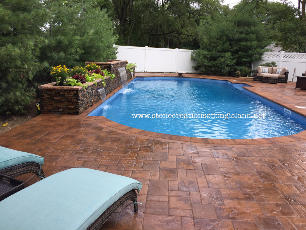 Imagen de piscina con fuente natural mediterránea grande rectangular en patio trasero con adoquines de hormigón