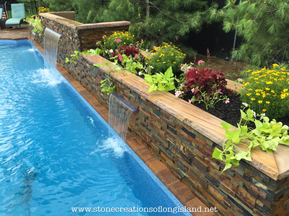 Imagen de piscina con fuente natural mediterránea grande rectangular en patio trasero con adoquines de hormigón