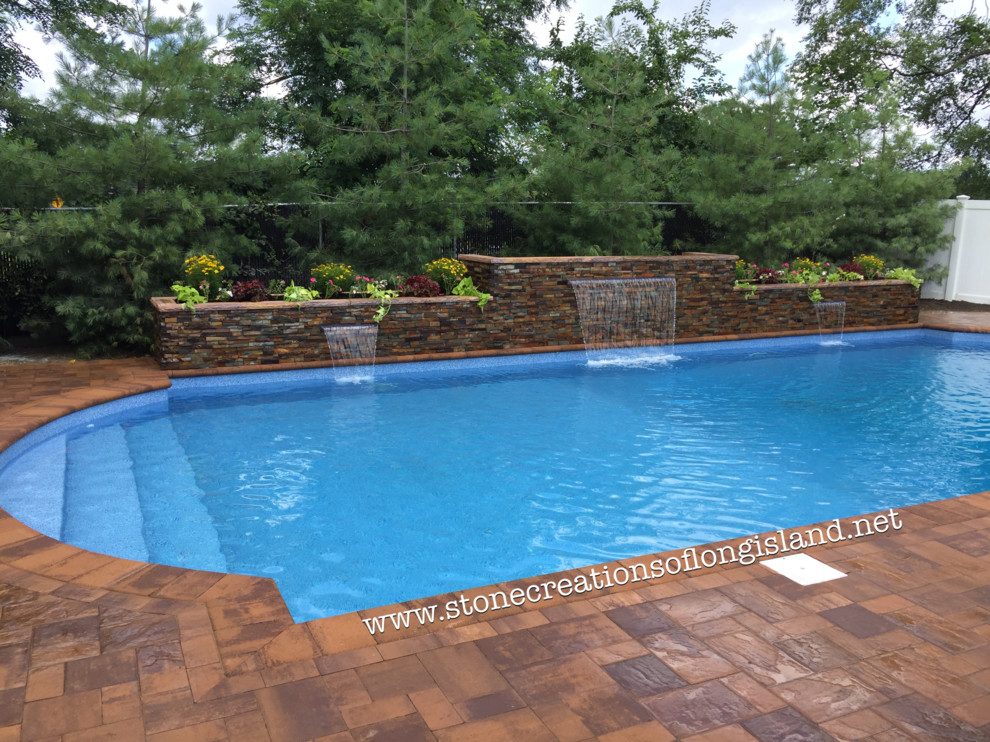 Foto de piscina con fuente natural mediterránea grande rectangular en patio trasero con adoquines de hormigón