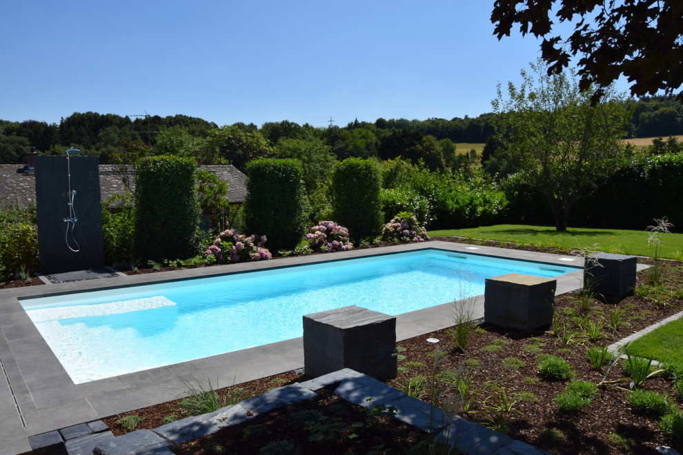 Mittelgroßer Moderner Pool neben dem Haus in rechteckiger Form mit Natursteinplatten in Frankfurt am Main
