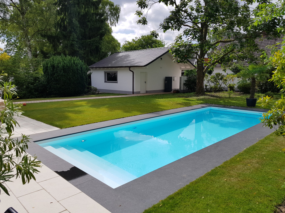 Foto de piscina clásica grande rectangular en patio delantero con adoquines de piedra natural