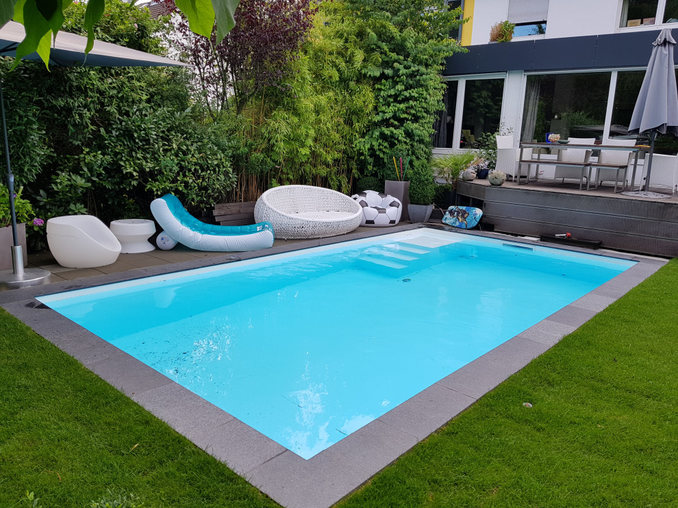 Exemple d'une piscine latérale tendance de taille moyenne et rectangle avec des pavés en pierre naturelle.