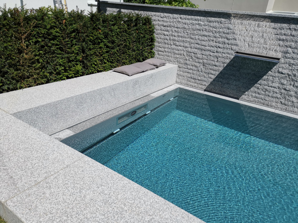 Idee per una grande piscina a sfioro infinito minimal rettangolare nel cortile laterale con fontane e pavimentazioni in pietra naturale