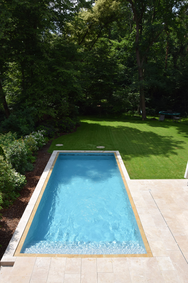 Imagen de piscina infinita mediterránea rectangular en patio lateral con adoquines de piedra natural