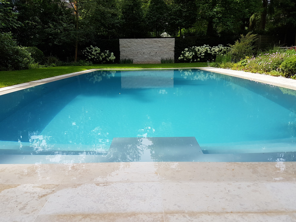 Großer Moderner Pool neben dem Haus in rechteckiger Form mit Wasserrutsche und Natursteinplatten in Frankfurt am Main