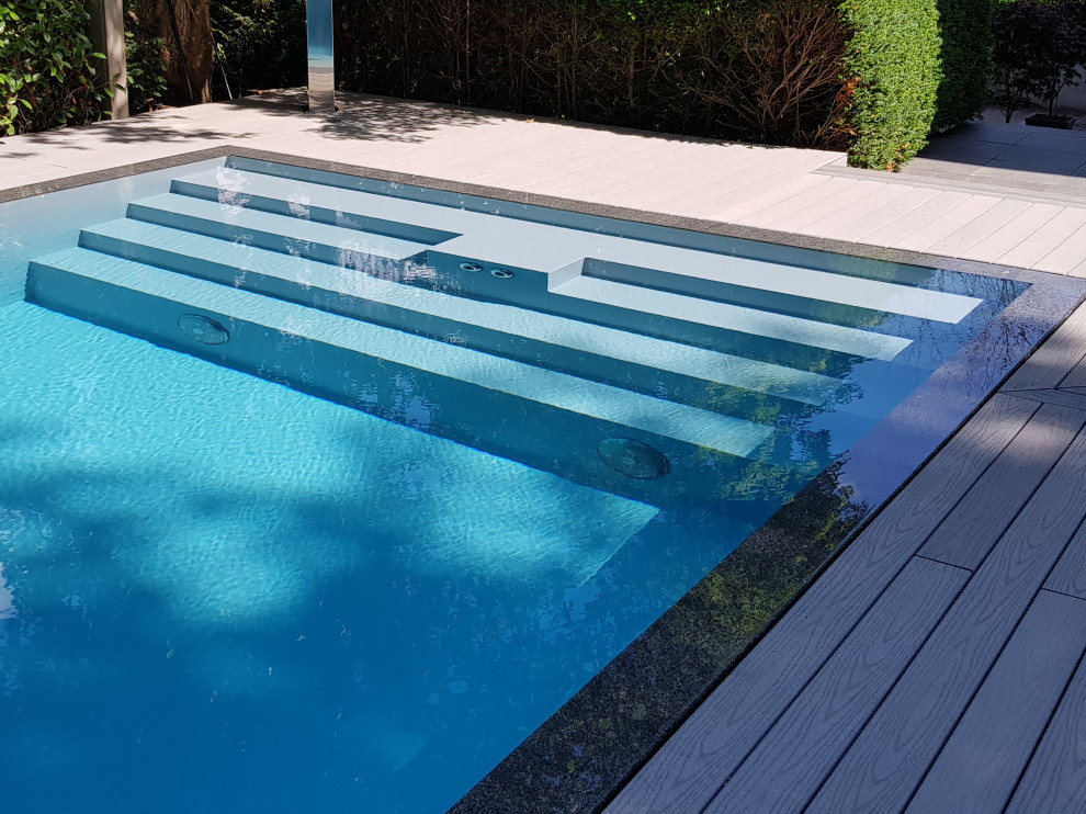 Imagen de piscina contemporánea grande rectangular en patio lateral con entablado