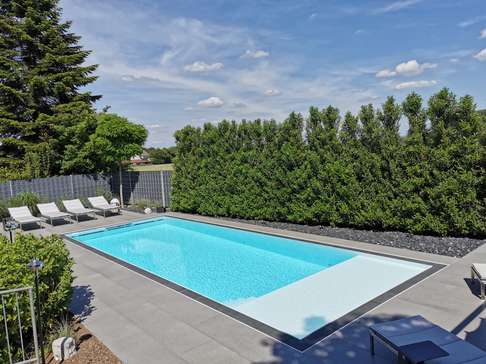 Inspiration for a large contemporary side yard tile and rectangular infinity pool remodel in Frankfurt