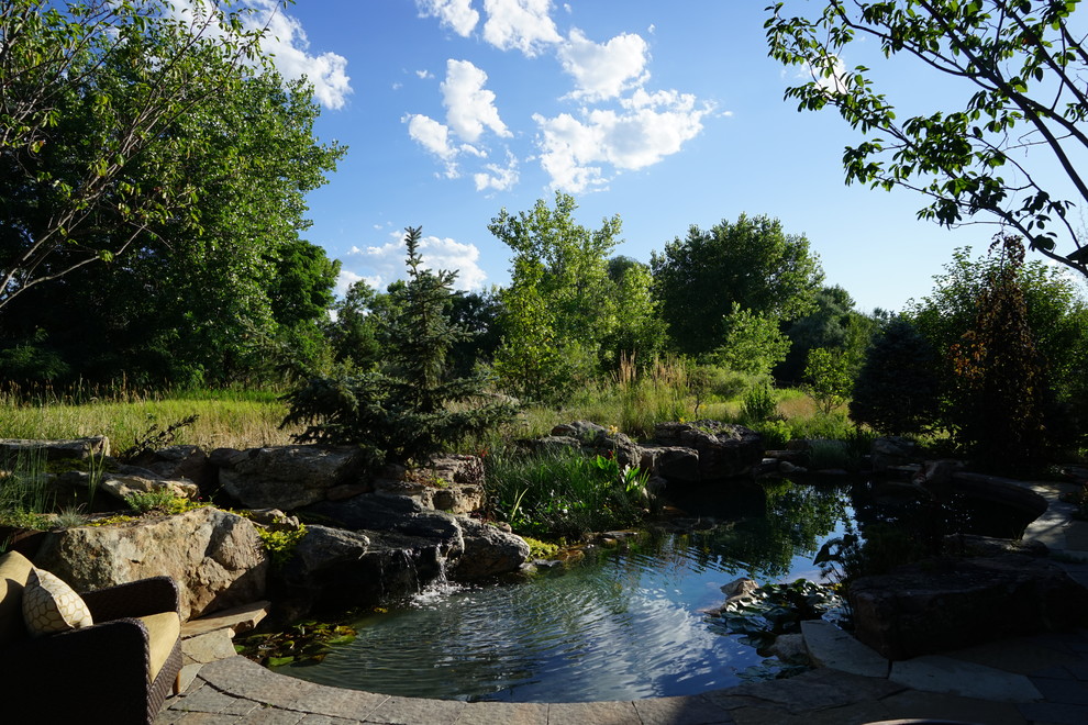 Diseño de piscina con fuente natural contemporánea de tamaño medio a medida en patio trasero con adoquines de piedra natural