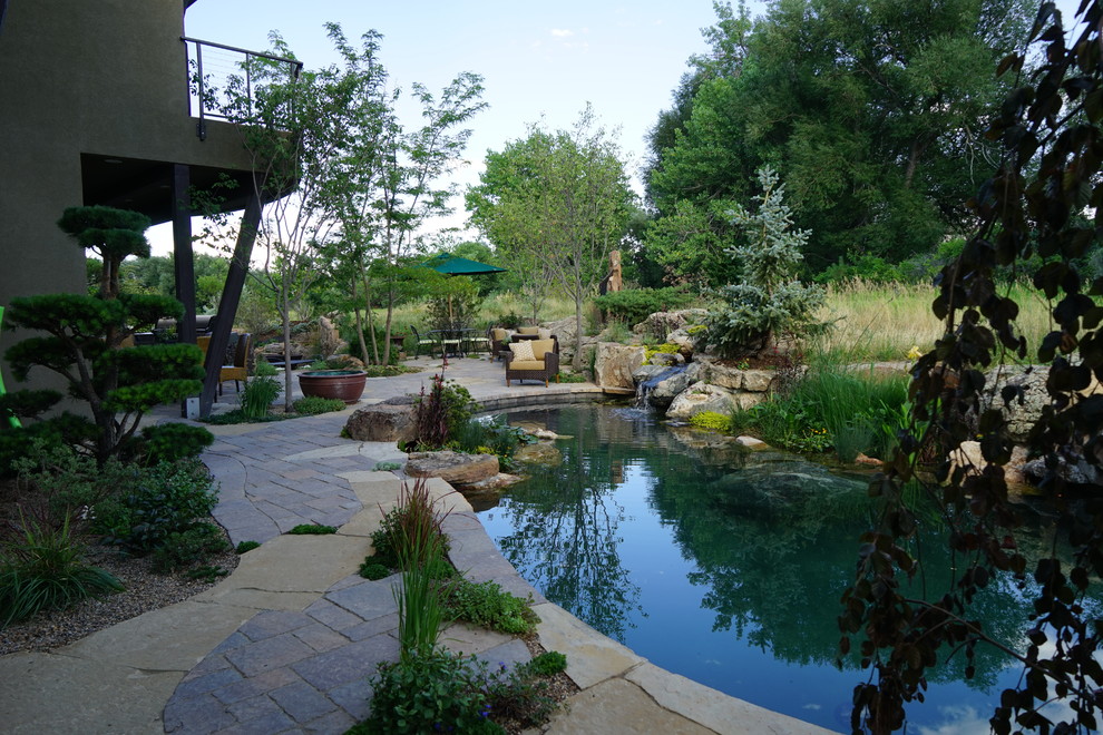 Aménagement d'une piscine naturelle et arrière contemporaine de taille moyenne et sur mesure avec un point d'eau et des pavés en pierre naturelle.