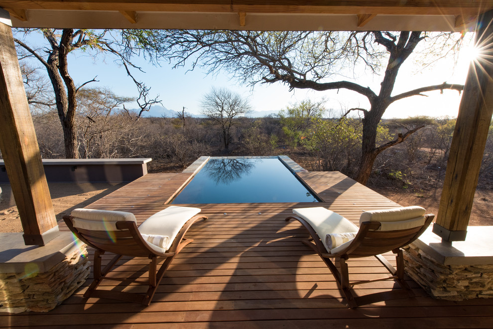 Réalisation d'une piscine sur toit champêtre de taille moyenne et rectangle avec une terrasse en bois.