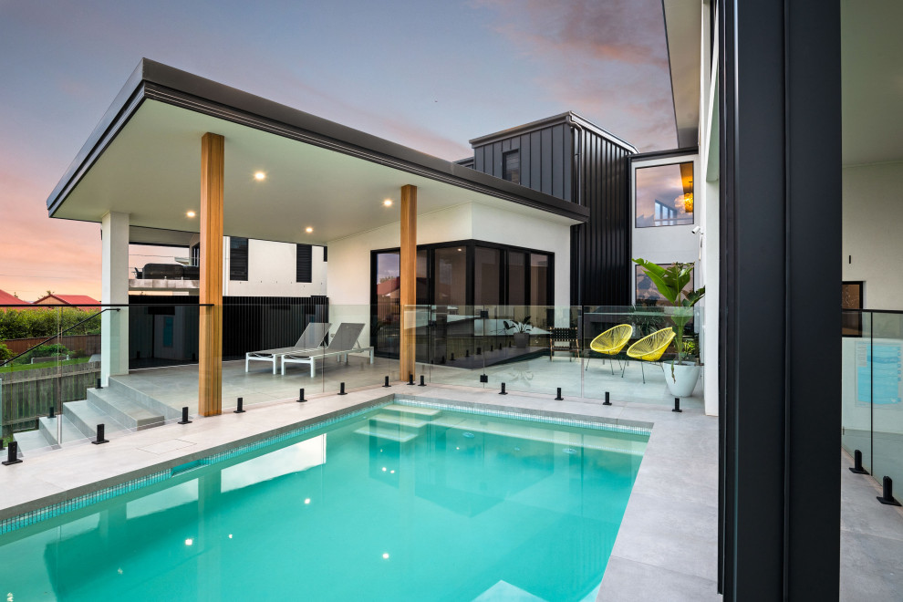 Идея дизайна: большой спортивный, прямоугольный бассейн на заднем дворе в современном стиле с покрытием из плитки