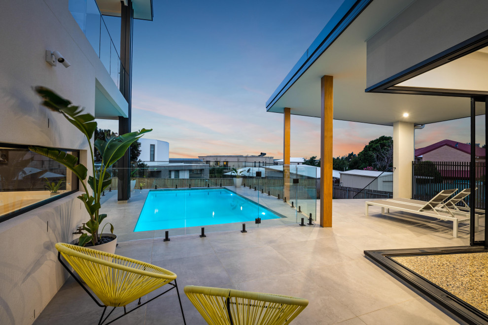 Idee per una piscina monocorsia minimal rettangolare di medie dimensioni e dietro casa con piastrelle
