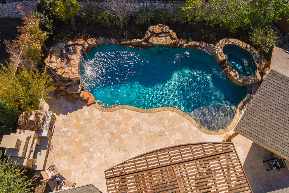 Mittelgroßer, Gefliester Mediterraner Schwimmteich hinter dem Haus in individueller Form mit Wasserspiel in Dallas