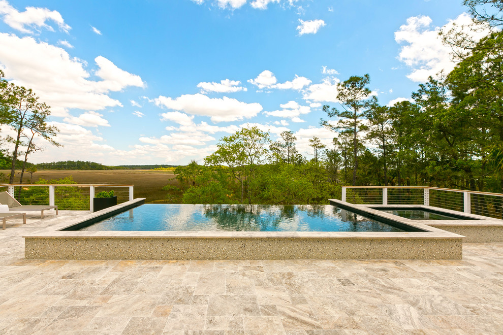 Modelo de piscinas y jacuzzis elevados costeros de tamaño medio rectangulares en patio trasero con adoquines de piedra natural