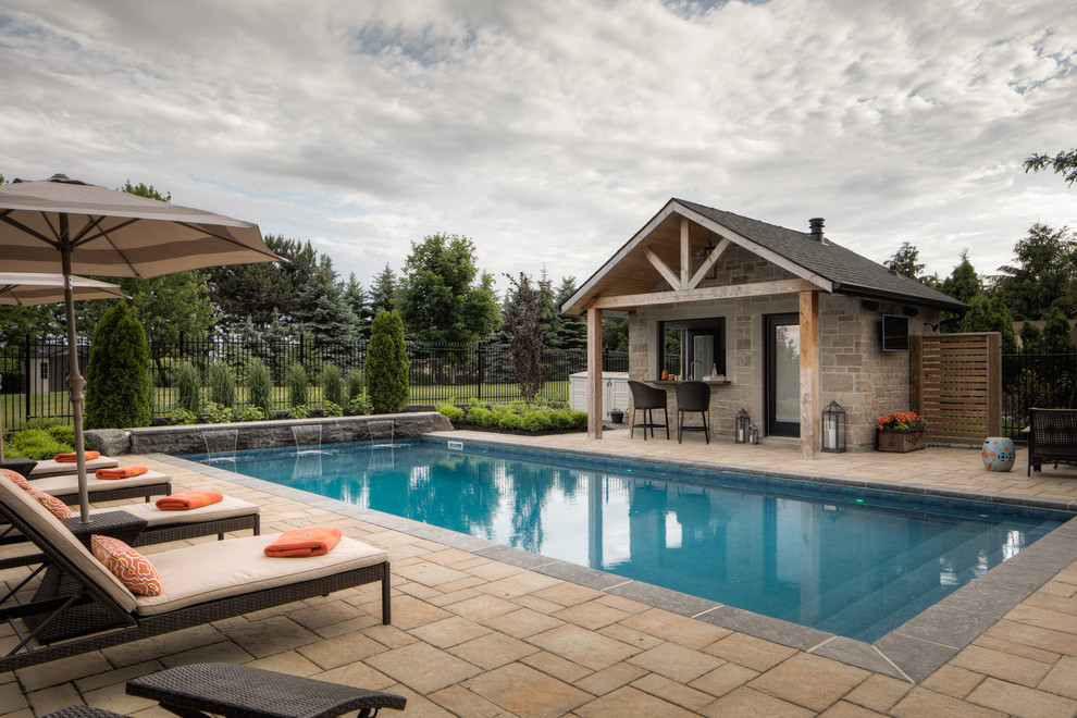 Photo of a large modern back rectangular lengths hot tub in Toronto with concrete paving.