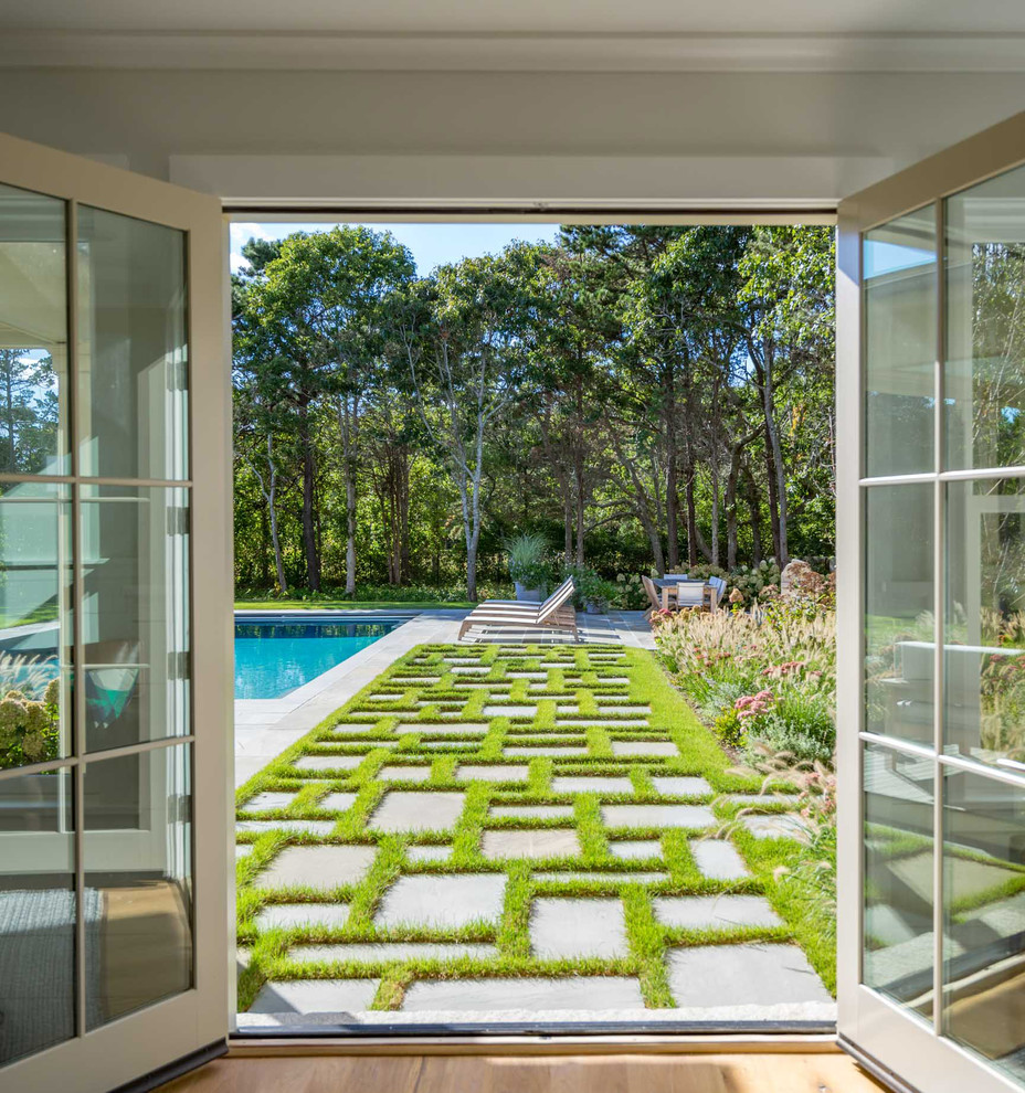 Foto de piscina alargada costera grande rectangular en patio trasero con adoquines de piedra natural