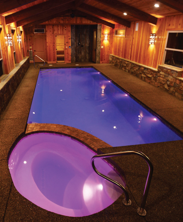 Exemple d'une piscine intérieure éclectique de taille moyenne et sur mesure avec des pavés en pierre naturelle.