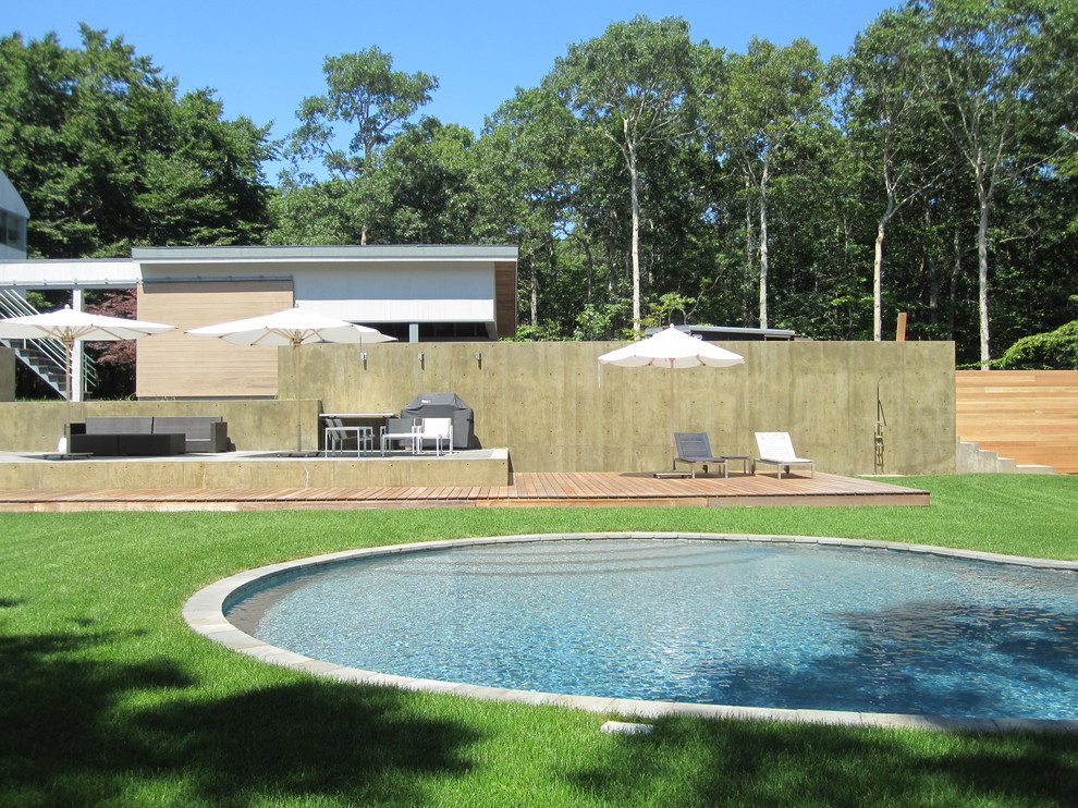 На фото: круглый бассейн в стиле модернизм с настилом и зоной барбекю