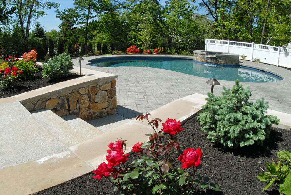 Photo of a medium sized modern back kidney-shaped swimming pool in Boston with natural stone paving.