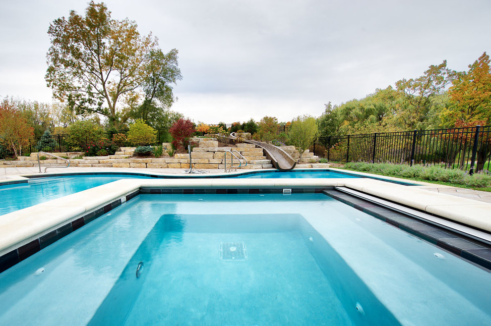 Пример оригинального дизайна: огромный естественный бассейн произвольной формы на заднем дворе в стиле неоклассика (современная классика) с мощением тротуарной плиткой и джакузи