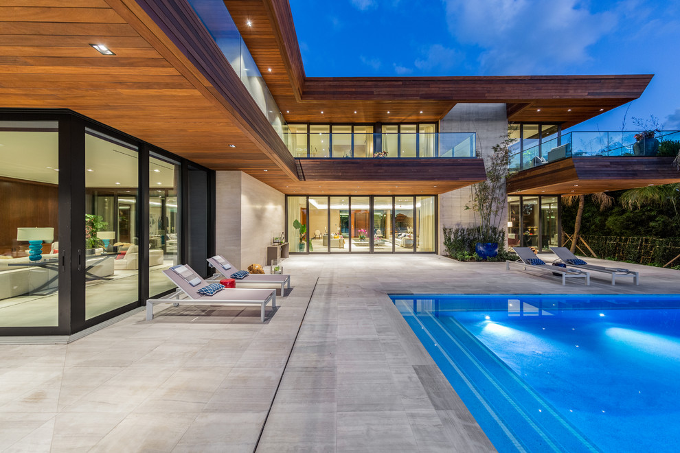 Идея дизайна: прямоугольный бассейн на заднем дворе в современном стиле с покрытием из плитки