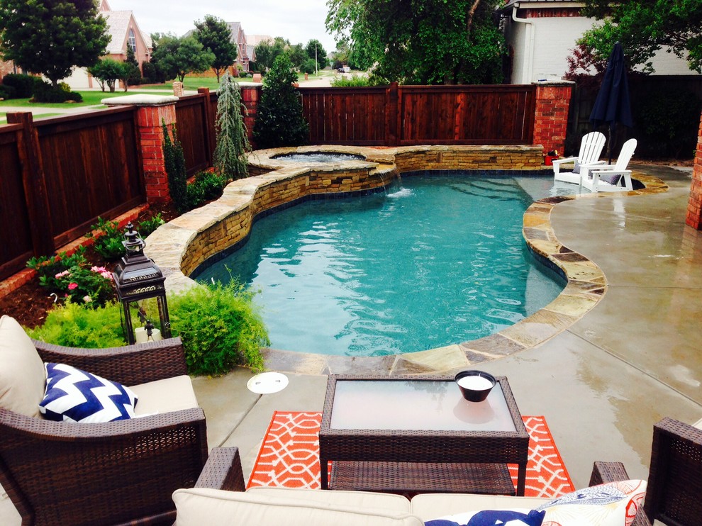 Diseño de piscina con fuente natural romántica de tamaño medio tipo riñón en patio lateral con suelo de hormigón estampado