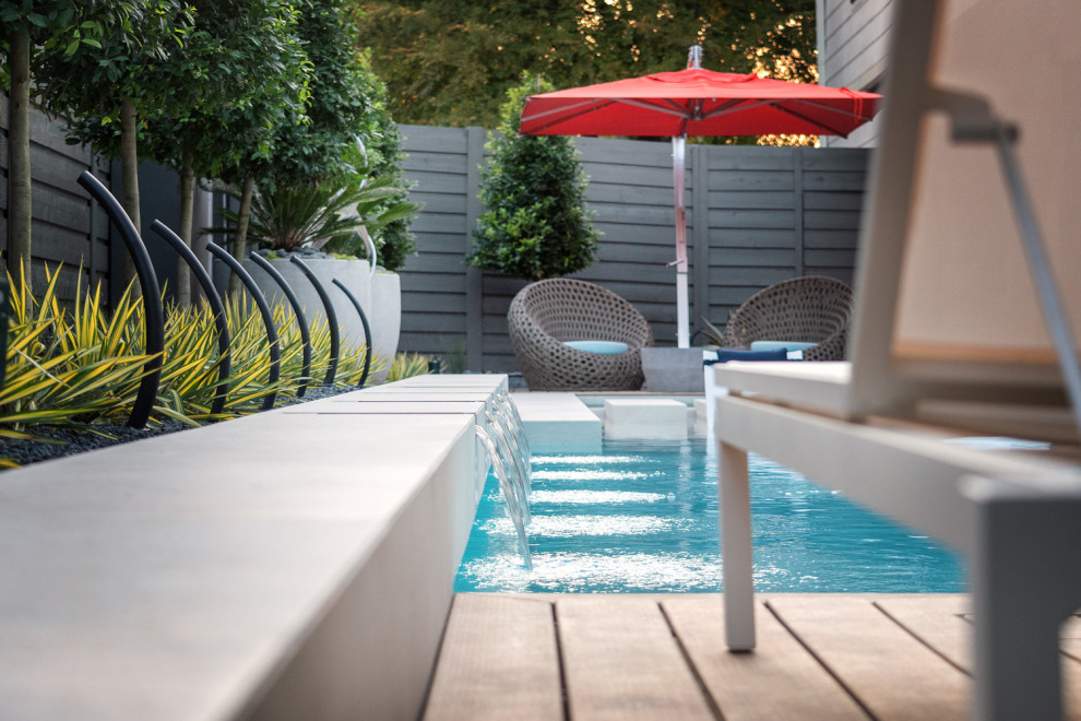 Großer Moderner Pool hinter dem Haus in rechteckiger Form mit Pool-Gartenbau und Natursteinplatten in Dallas