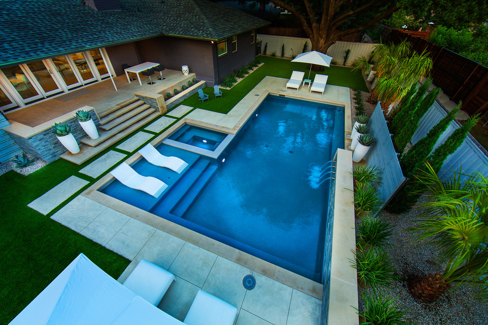 Immagine di una piscina moderna rettangolare di medie dimensioni e dietro casa con una vasca idromassaggio
