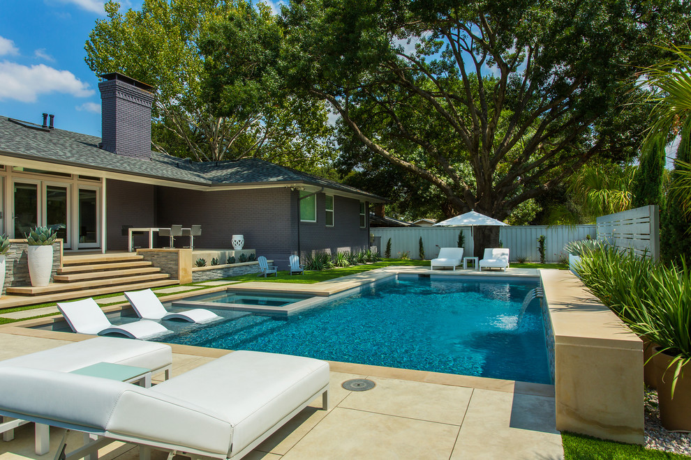 На фото: прямоугольный бассейн среднего размера на заднем дворе в стиле модернизм с джакузи с