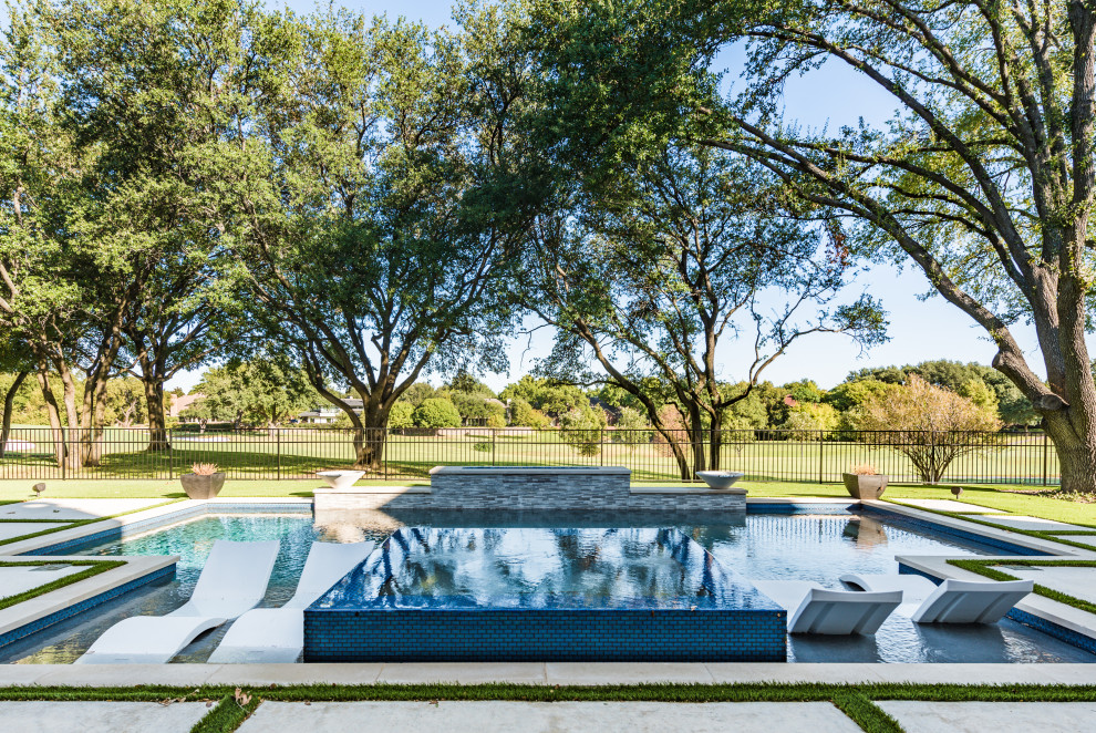 На фото: естественный, прямоугольный бассейн среднего размера на заднем дворе в стиле неоклассика (современная классика) с джакузи и мощением тротуарной плиткой