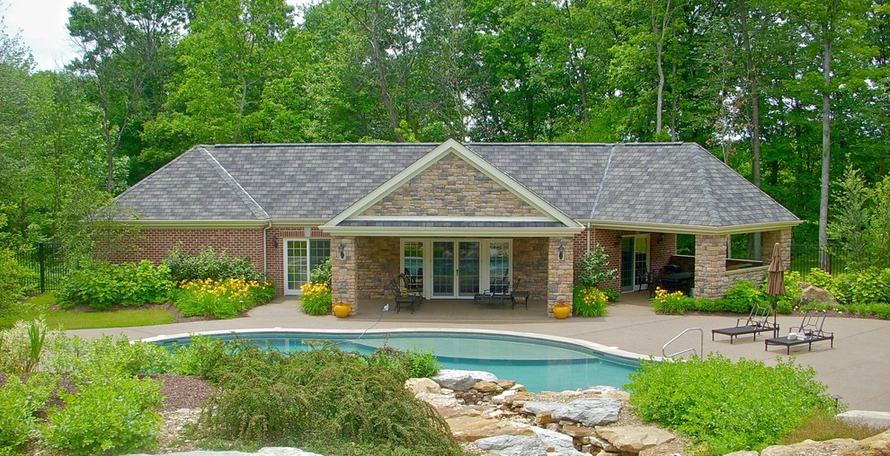 Foto de casa de la piscina y piscina natural tradicional extra grande a medida en patio trasero con suelo de hormigón estampado