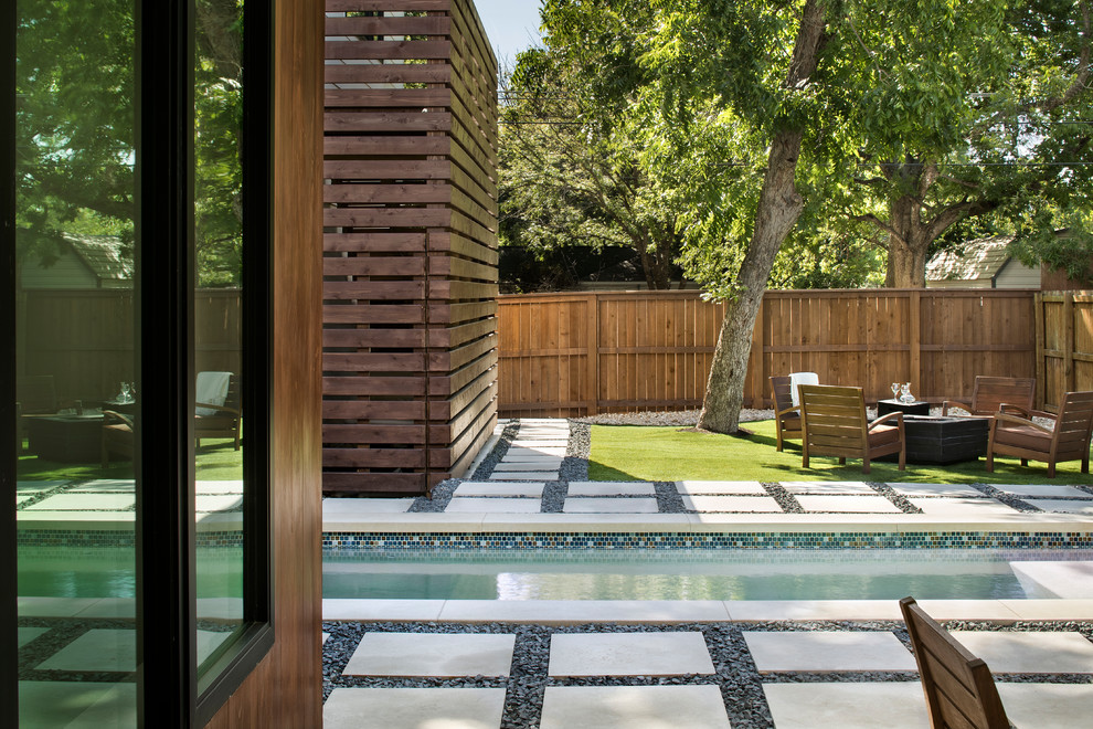 Diseño de piscina tradicional renovada pequeña rectangular en patio trasero con adoquines de piedra natural
