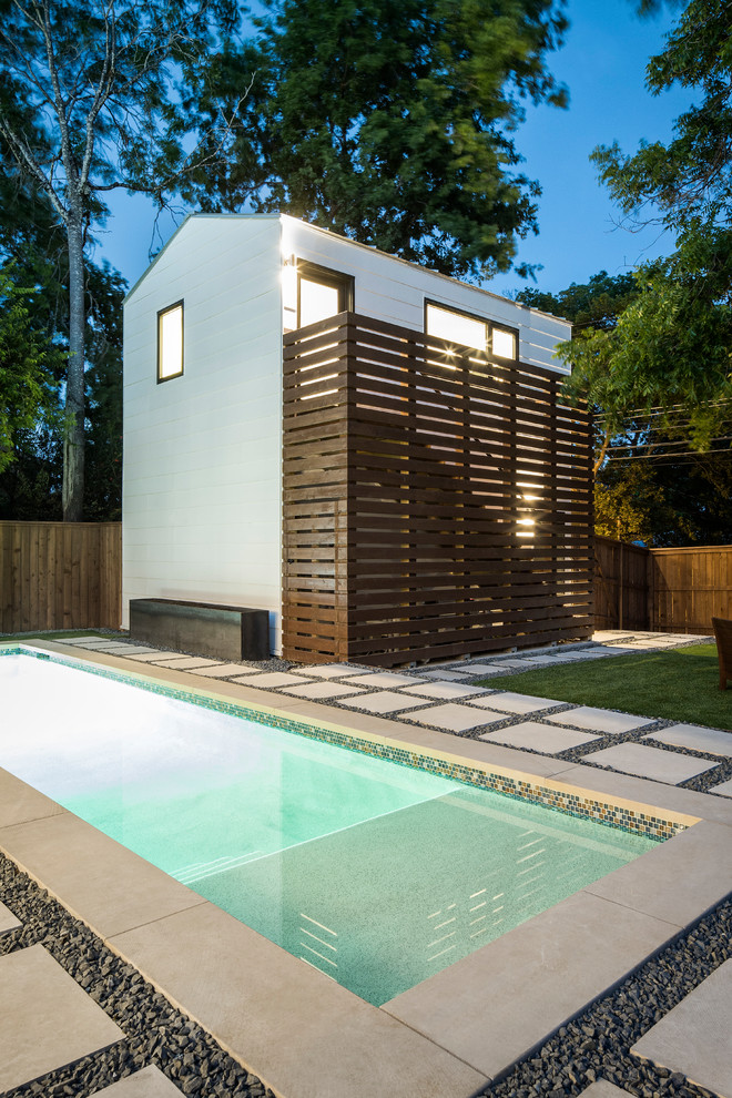Modelo de piscina clásica renovada pequeña rectangular en patio trasero con adoquines de piedra natural