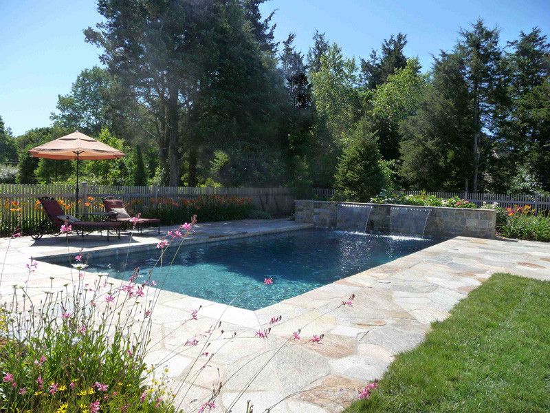 Foto de piscina con fuente alargada clásica rectangular en patio trasero con adoquines de piedra natural